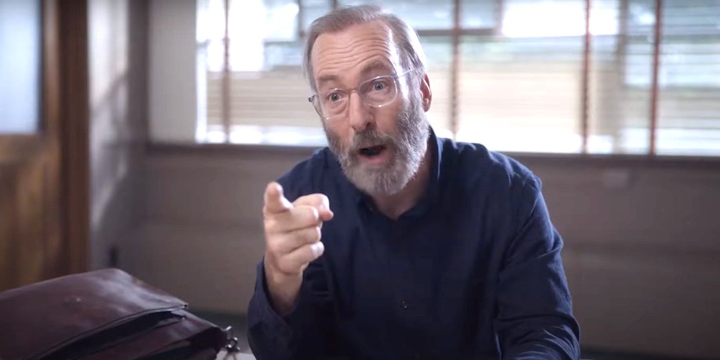 Bob Odenkirk in Lucky Hank wearing a thick beard and glasses, pointing angrily at someone during a meeting