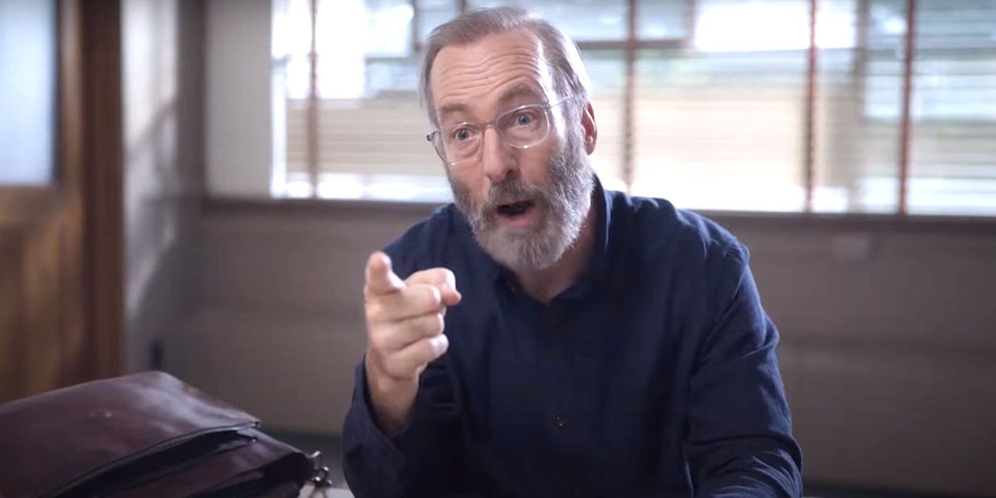 Bob Odenkirk, barbudo y con gafas en Lucky Hank, hace un gesto enojado a alguien durante un encuentro.