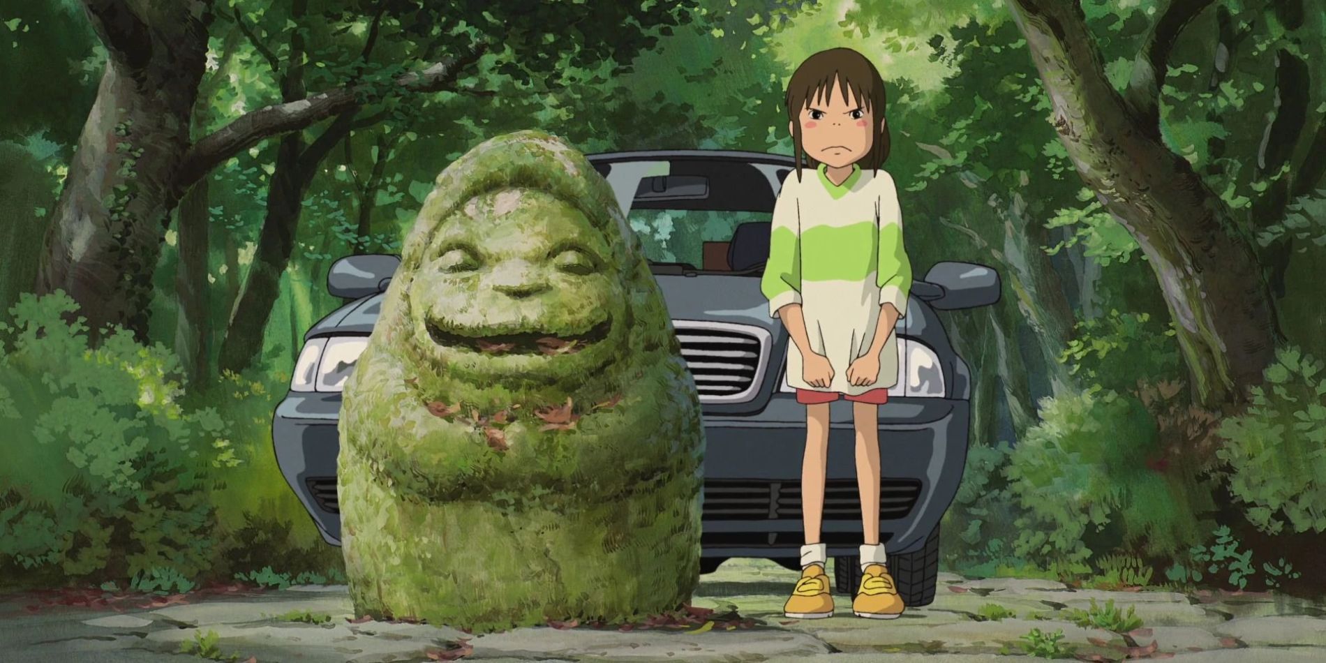 Chihiro standing next to a statue looking angry at the beginning of Spirited Away.