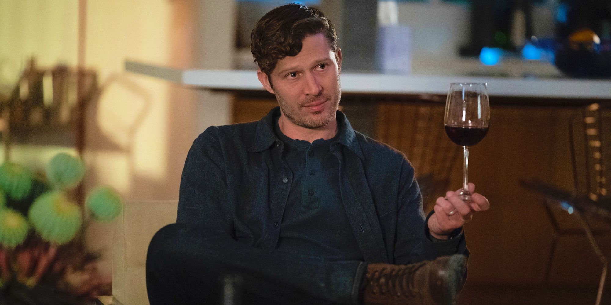 Elias Voit looking smug and holding a wine glass in Criminal Minds: Evolution