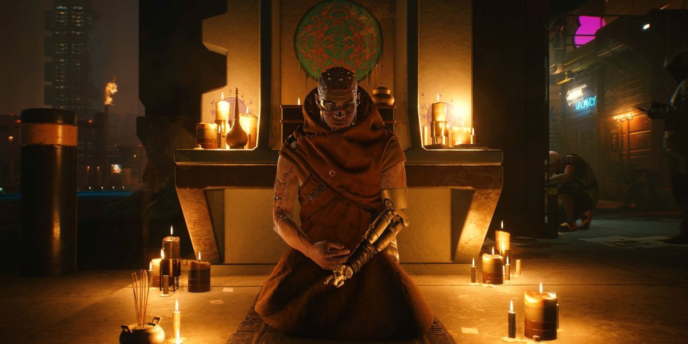 A monk from Cyberpunk 2077 kneeling on the ground next to some lit candles.