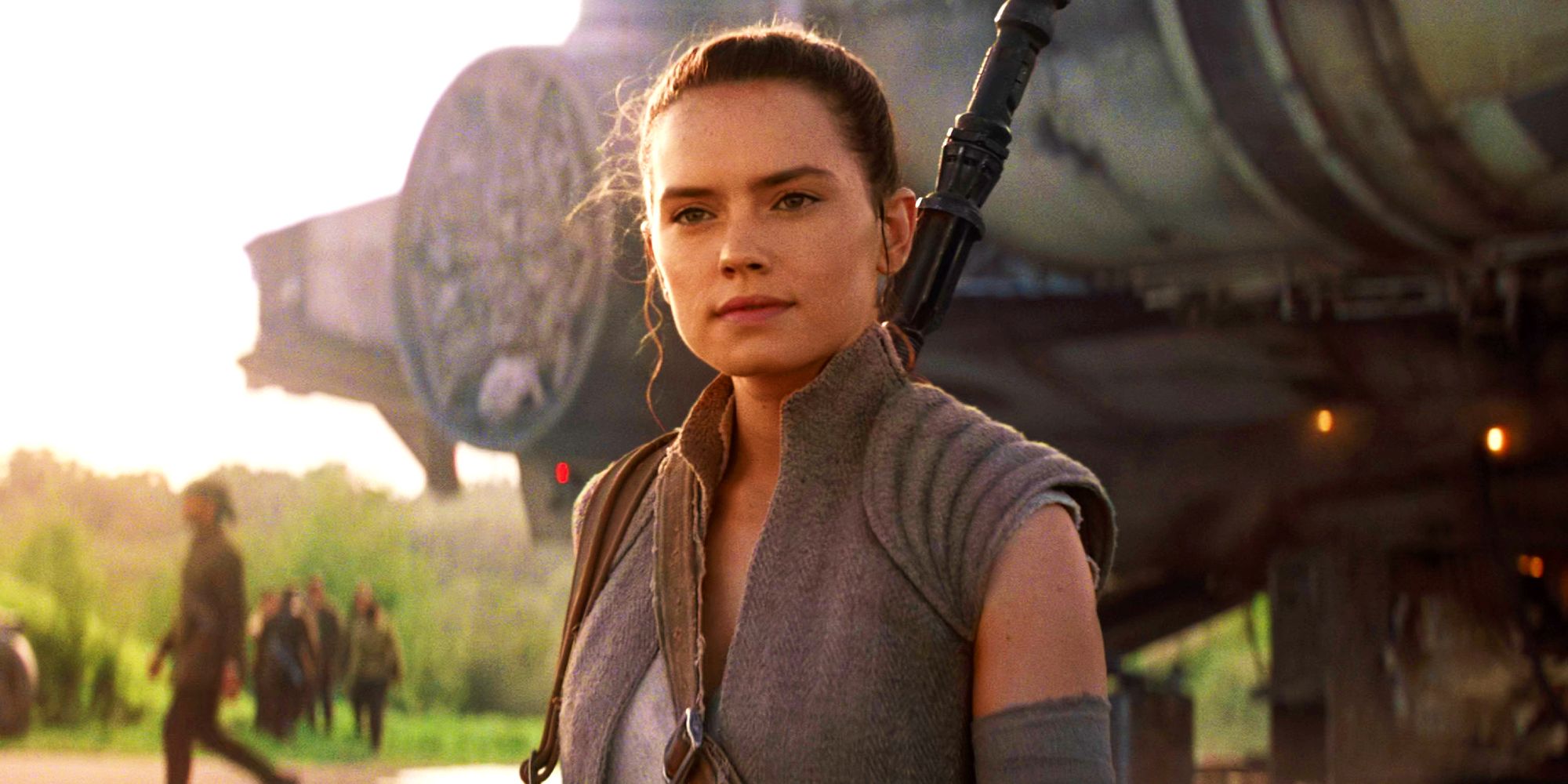 Daisy Ridley as Rey in front of the Millennium Falcon in Star Wars: The Force Awakens.