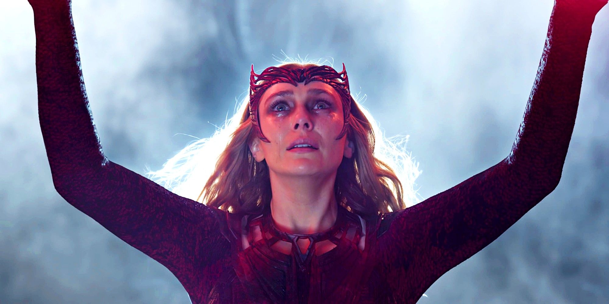 Elizabeth Olsen raising her arms up as she performs magic as Scarlet Witch in Doctor Strange in the Multiverse of Madness