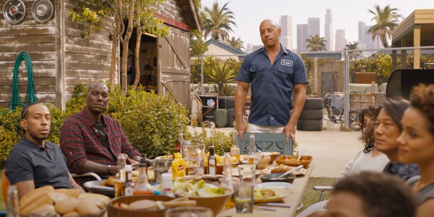 Ludacris, Tyrese Gibson, Vin Diesel, Michelle Rodriguez, Sung Kang, and Nathalie Emmanuel around a table in Fast X.