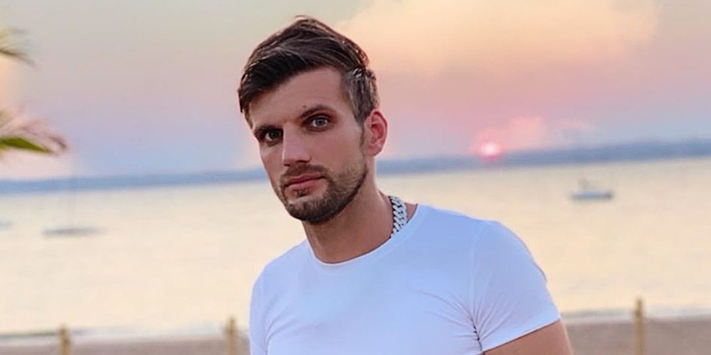 Florian Sukaj from Darcey & Stacey posing in a white t-shirt in front of a sunset