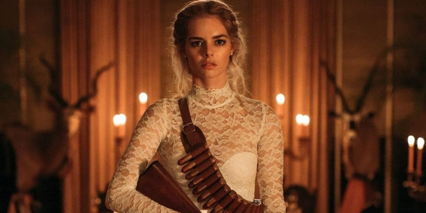 Grace (Samara Weaving) armed for the hunt in Ready or Not wearing her bridal dress