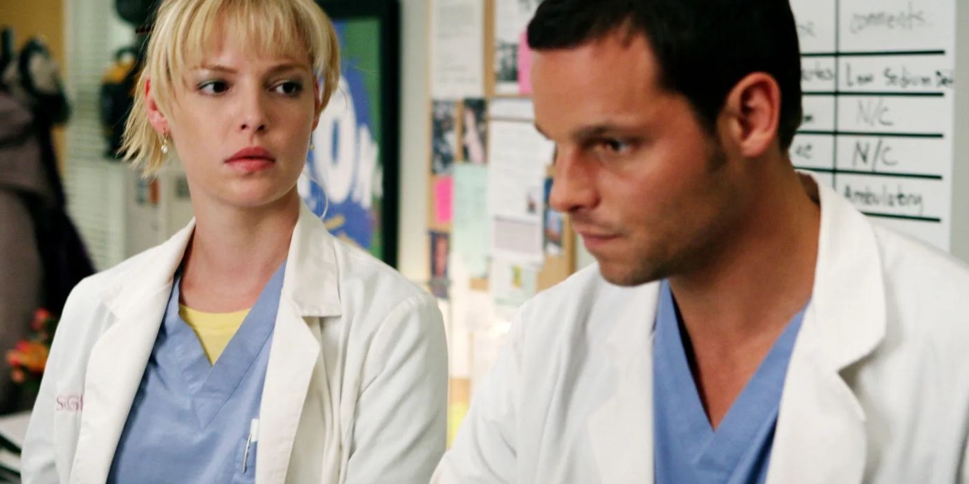 Izzie and Alex standing at the hospital in front of the white board on Grey's Anatomy