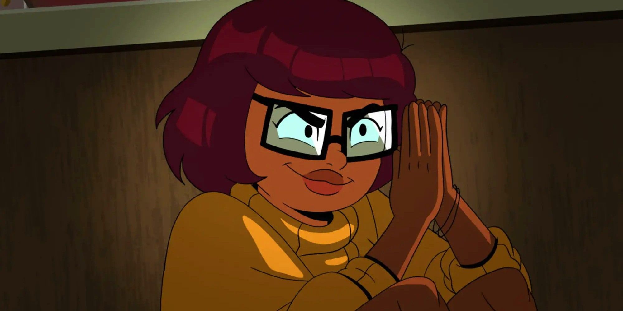 HBO's Velma pressing her hands together and looking like she's scheming