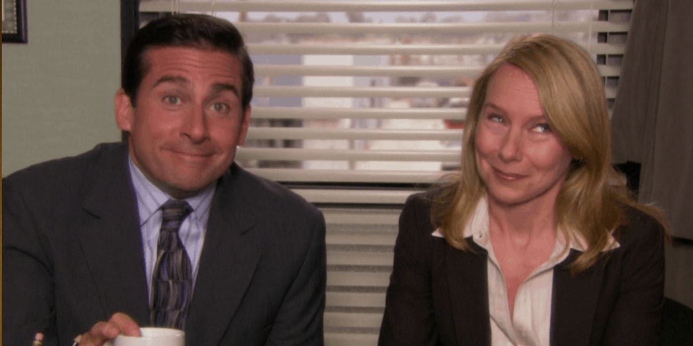 Holly and Michael sitting at his desk smirking on The Office