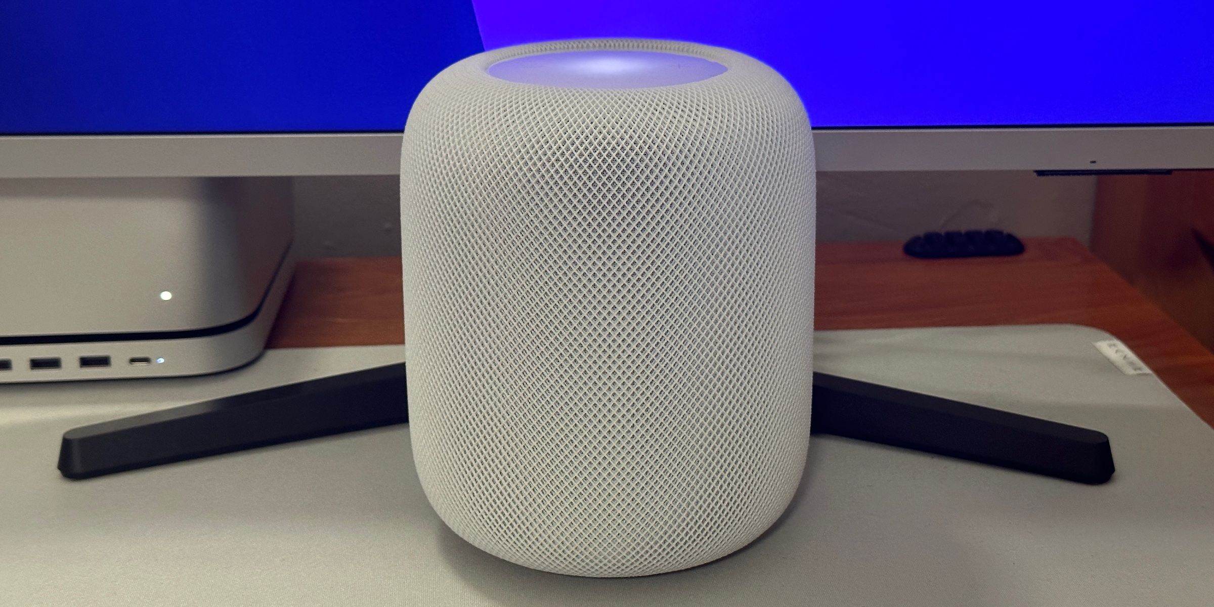 A second-generation white HomePod on a desk. 