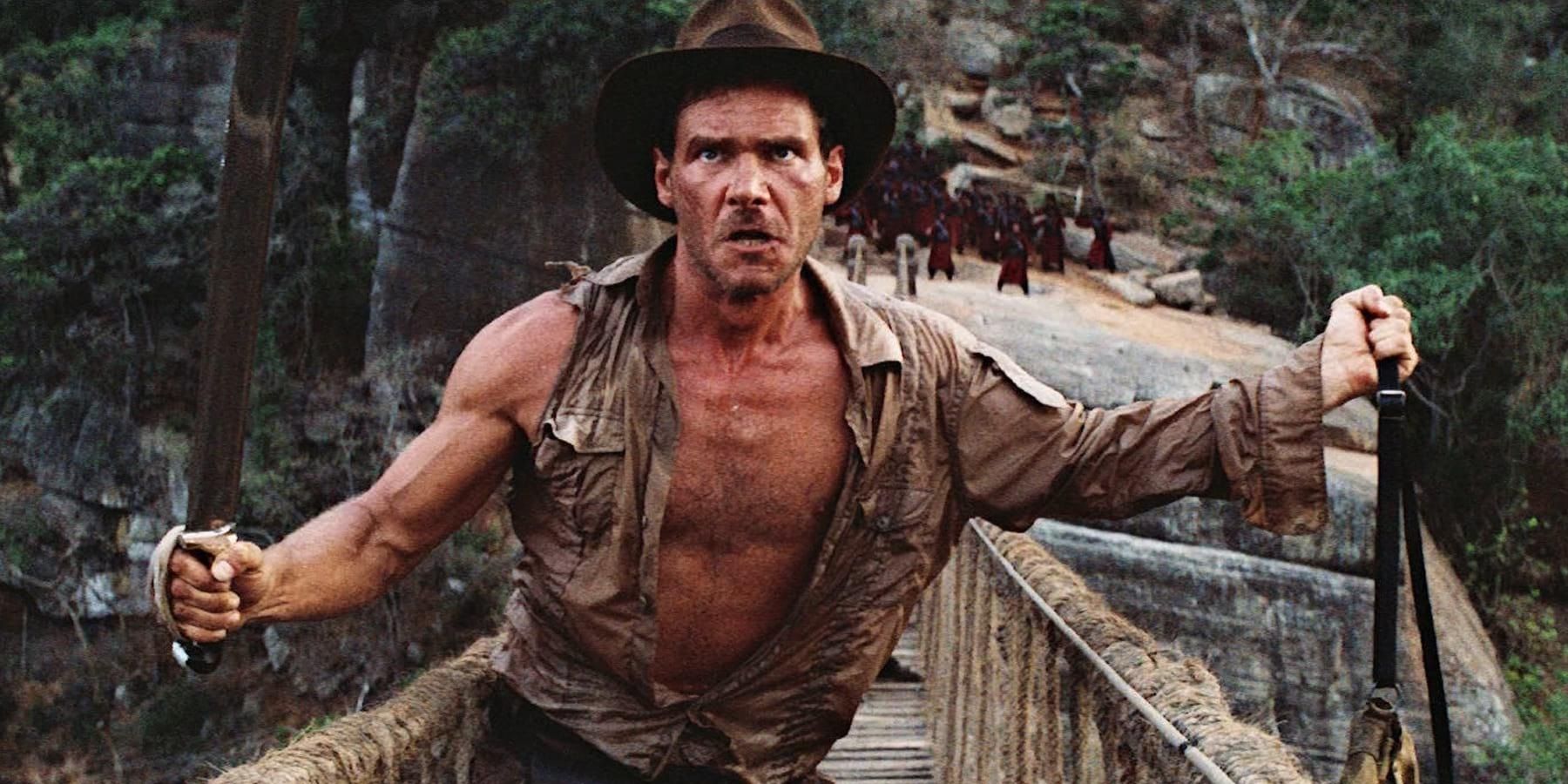 Harrison Ford as Indiana Jones on a rope bridge in Indiana Jones and the Temple of Doom.