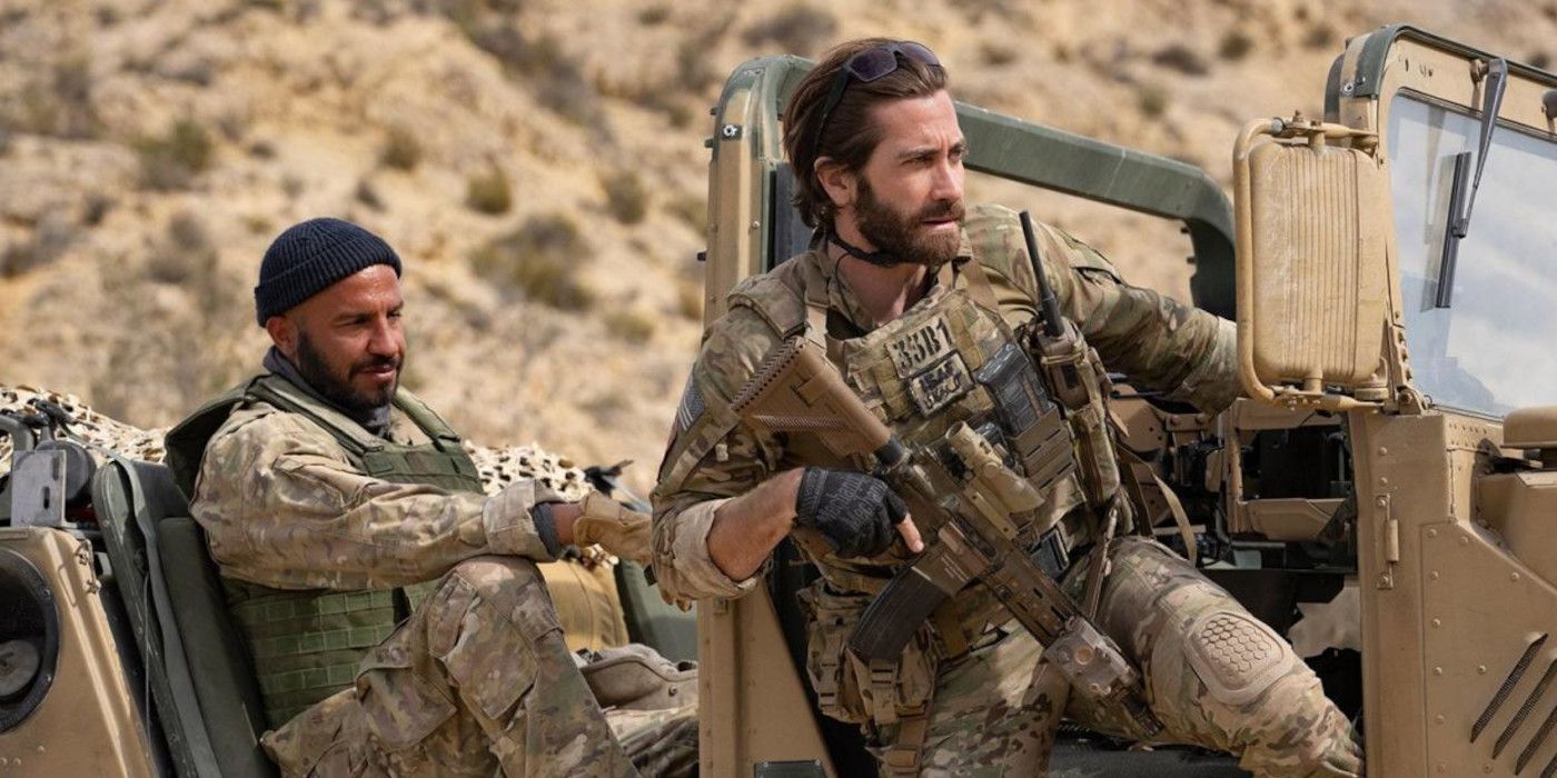 Jake Gyllenhaal and Dar Salim in The Covenant in military uniforms riding on a jeep