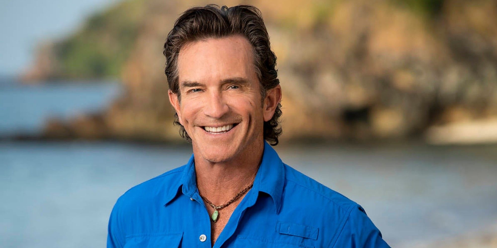 Jeff Probst Survivor 44 vestindo camisa azul e colar sorrindo