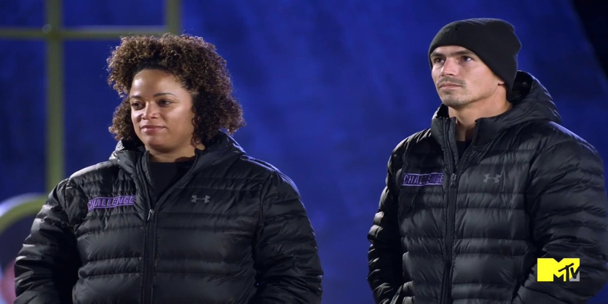 Jordan and Aneesa on The Challenge Ride or Dies wearing matching black puffer jackets with a serious expression