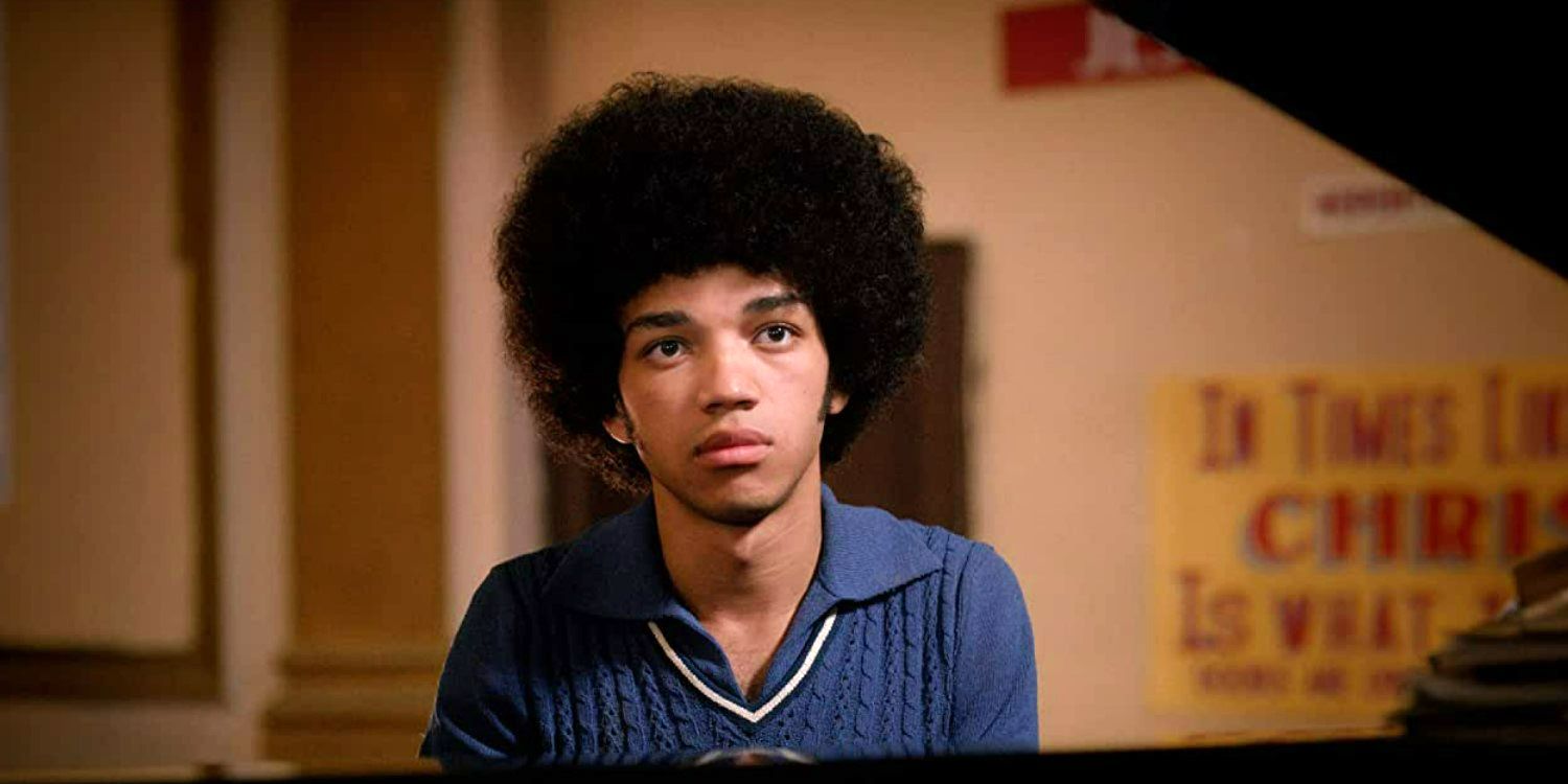 Justice Smith as Zeke looking serious sitting behind piano in The Get Down