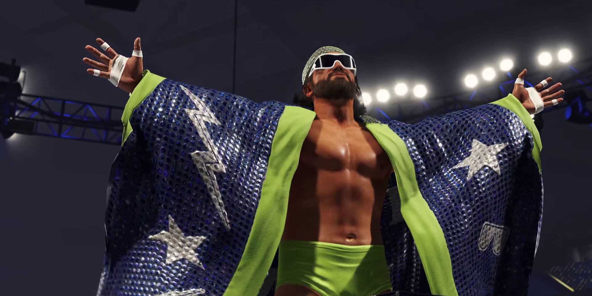 Macho Man Randy Savage, wearing green shorts and a sparkly, purple cape adorned with stars, stands with his arms outstretched in a trailer for WWE 2K23