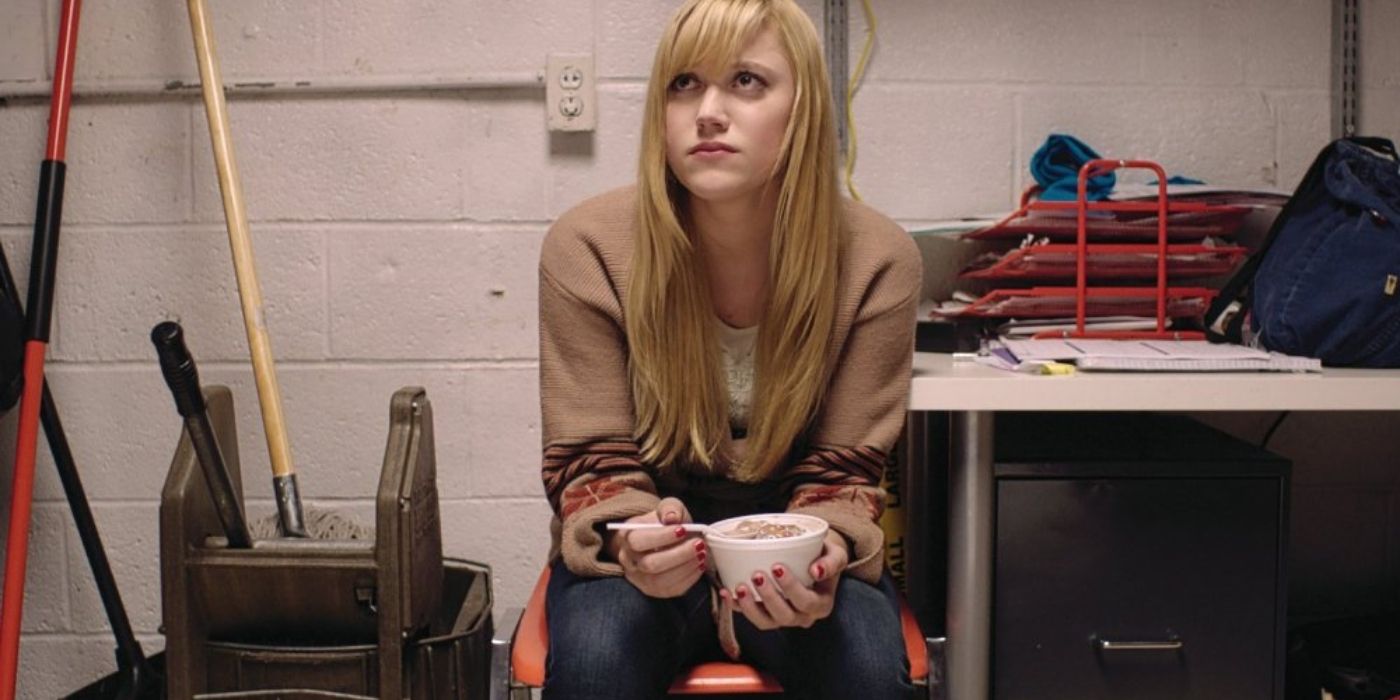 Maika Monroe as Jay sitting and holding a bowl of food in It Follows