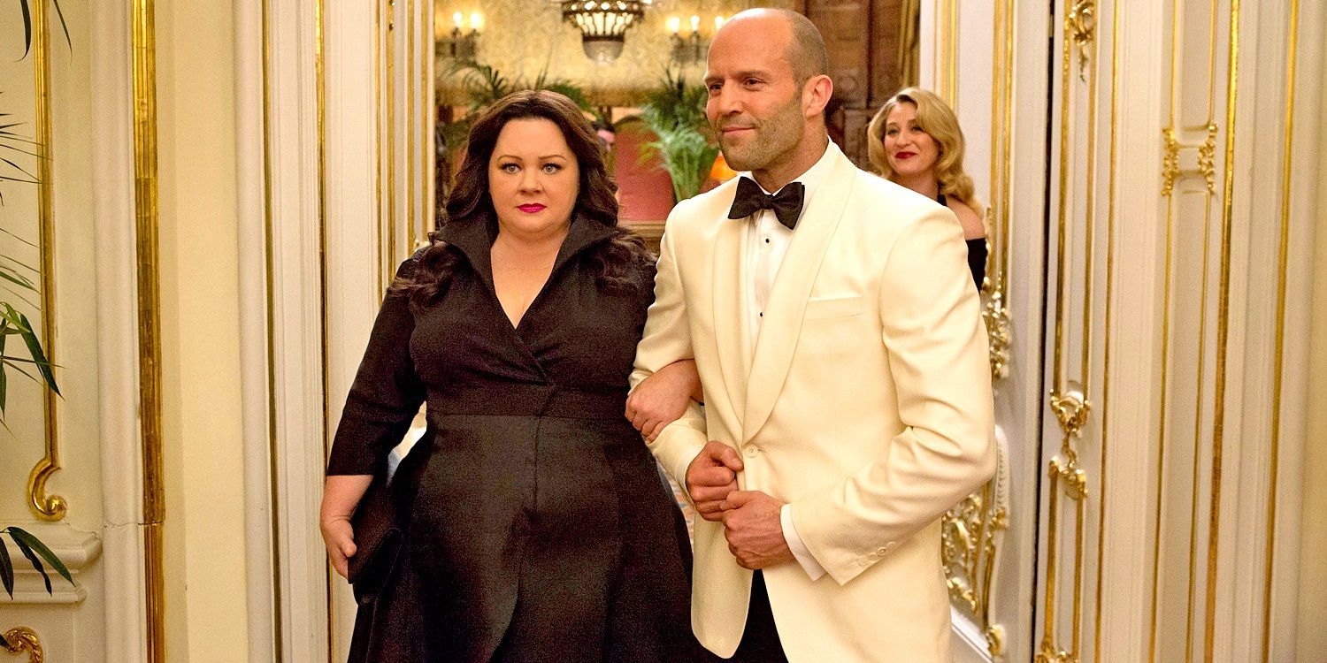 Melissa McCarthy linking arms with Jason Statham in Spy