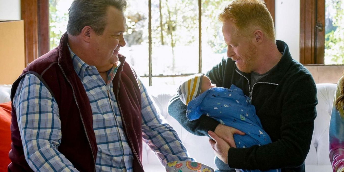 Cam and Mitch holding baby Rexford on Modern Family