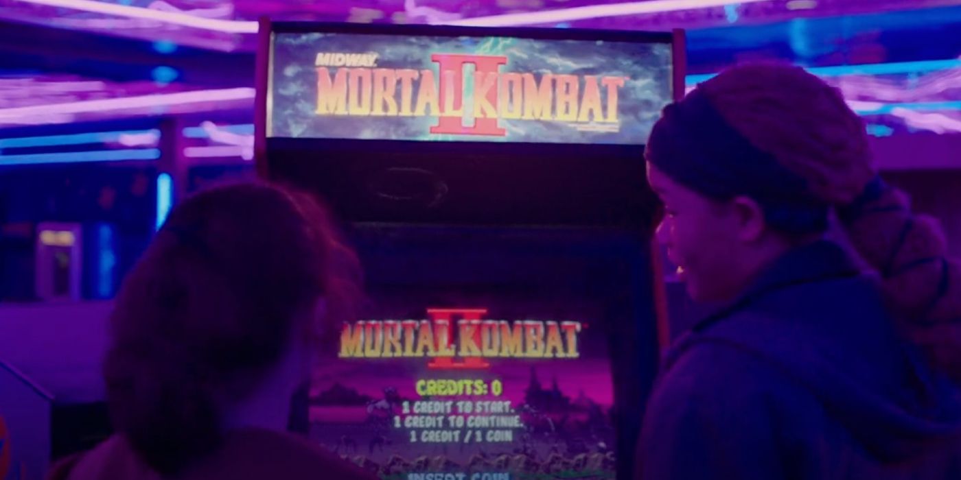 Ellie and Riley stood in front of the Mortal Kombat II machine in Last of Us episode 7