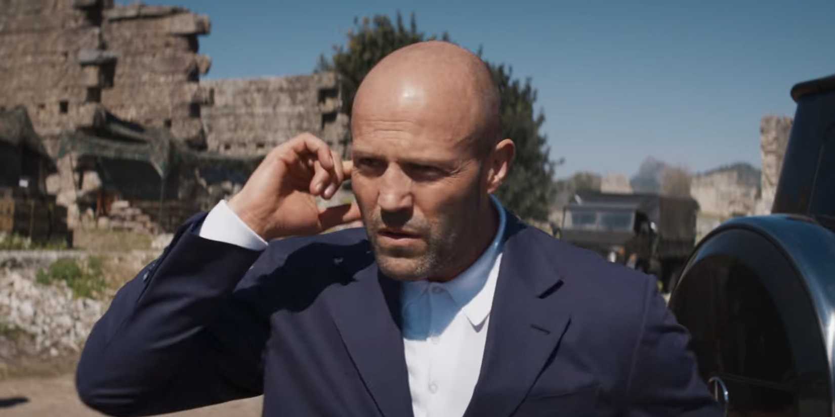 Orson Fortune (Jason Statham) talking to someone in his ear in Operation Fortune Ruse de Guerre 