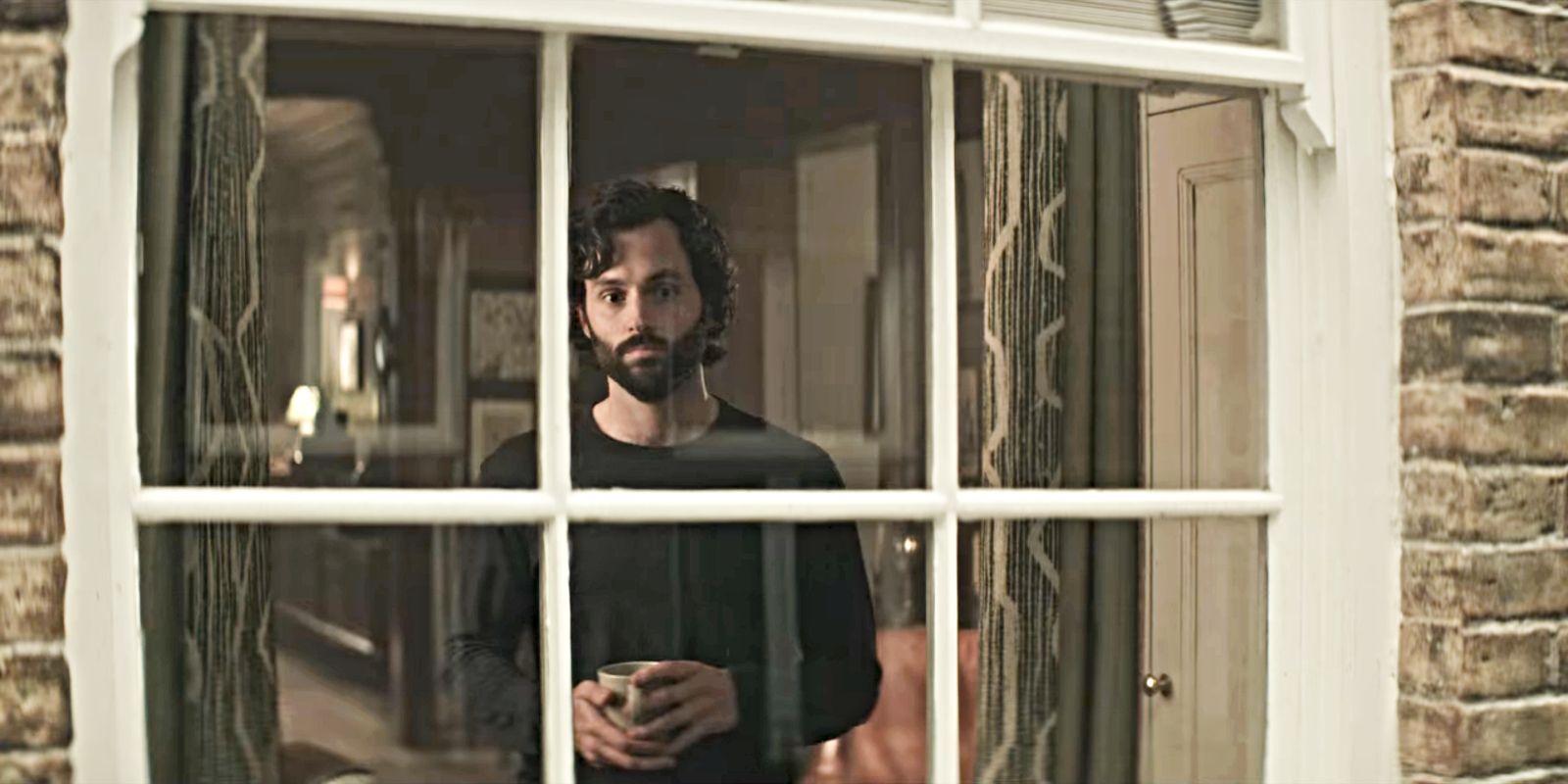 Penn Badgley as Joe Goldberg at his window