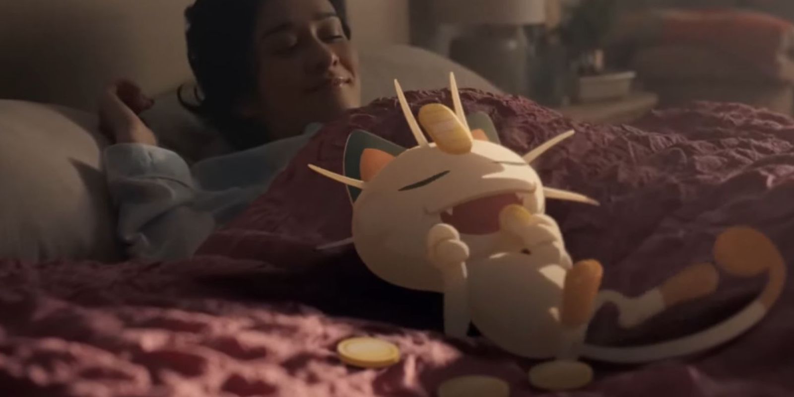 Gambar Pokémon Sleep seorang wanita di tempat tidur tidur dengan Meowth berbaring di tempat tidur di sampingnya tidur di atas selimut.