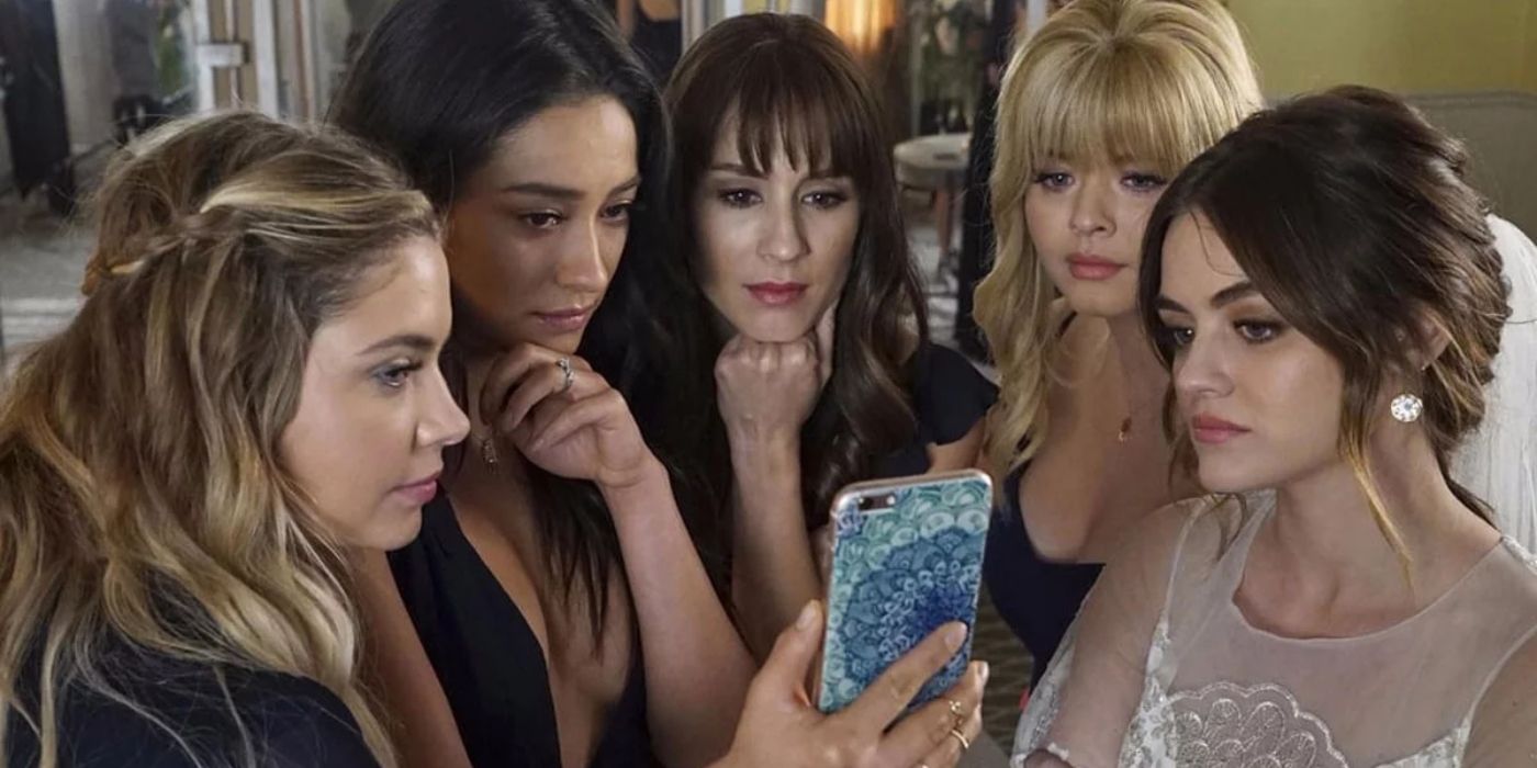 Hanna, Emily, Spencer, Ali and Aria looking at a cell phone on Pretty Little Liars