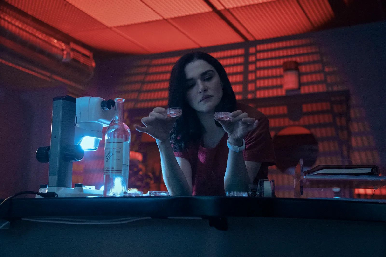 Rachel Weisz in Dead Ringers sitting at a lab table looking at samples with intrigue