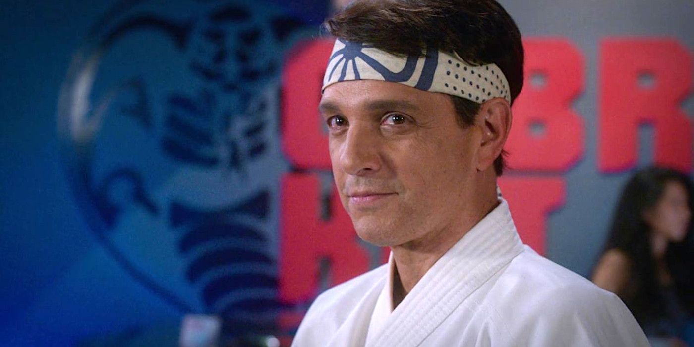 Ralph Macchio as Daniel in Cobra Kai season 5 wearing a white karate tunic and headband looking slightly smug