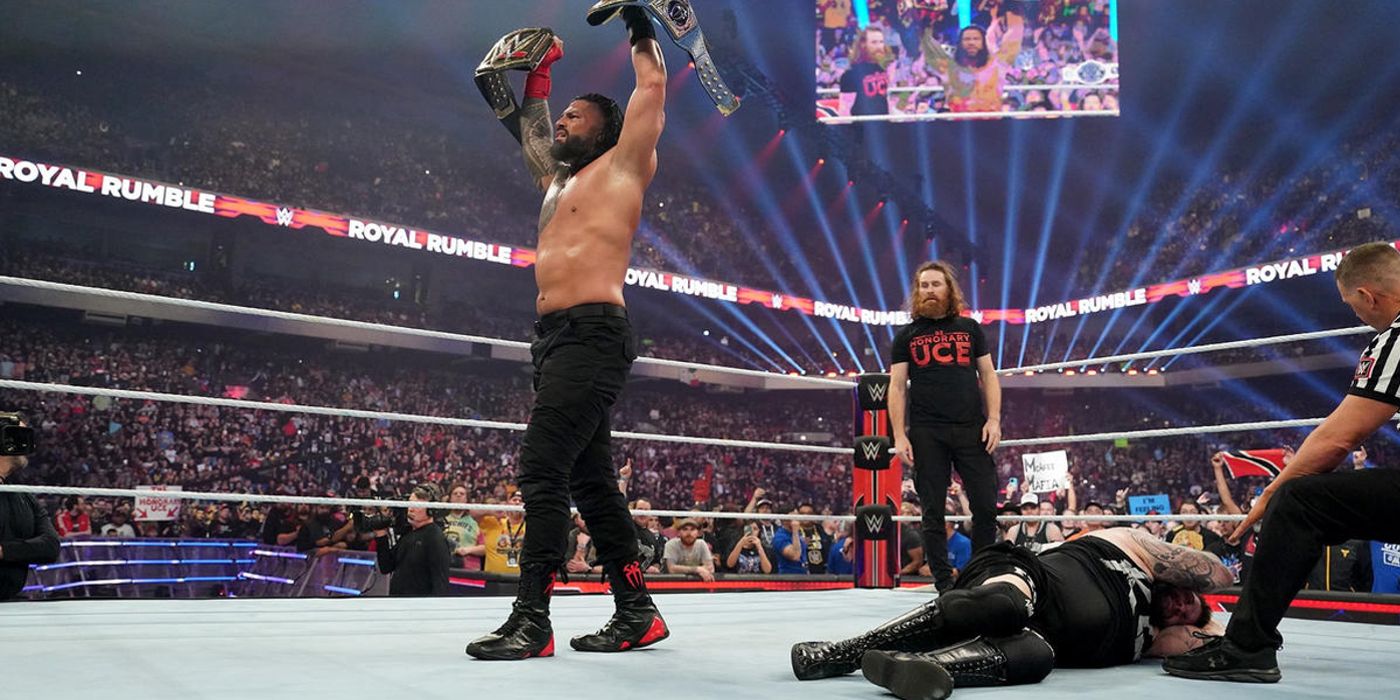 Roman Reigns holds the WWE and Universal Championships overheard after beating Kevin Owens at the Royal Rumble in 2023.