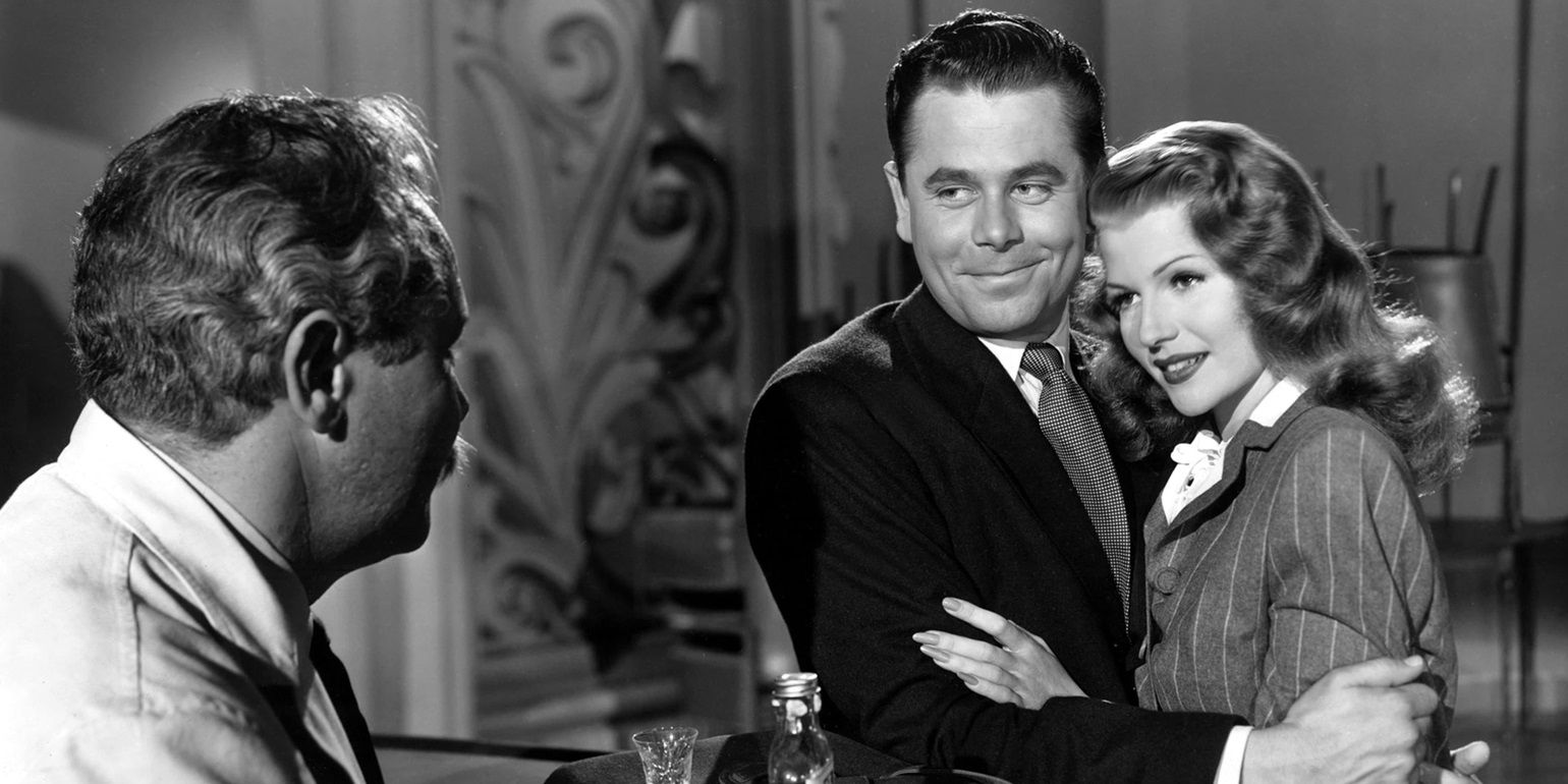 Rita Hayworth and Glenn Ford wrap their arms around each other in Gilda.