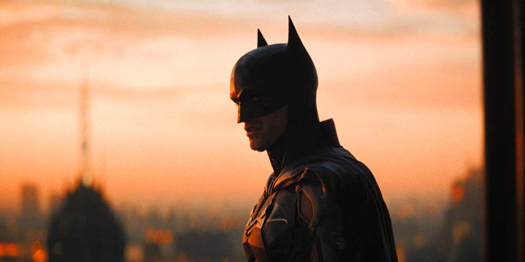 Robert Pattinson as Batman in The Batman looking over Gotham