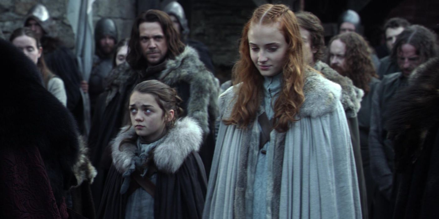 Sansa and Arya Stark standing in Winterfell's courtyard in Game of Thrones season 1 episode 1