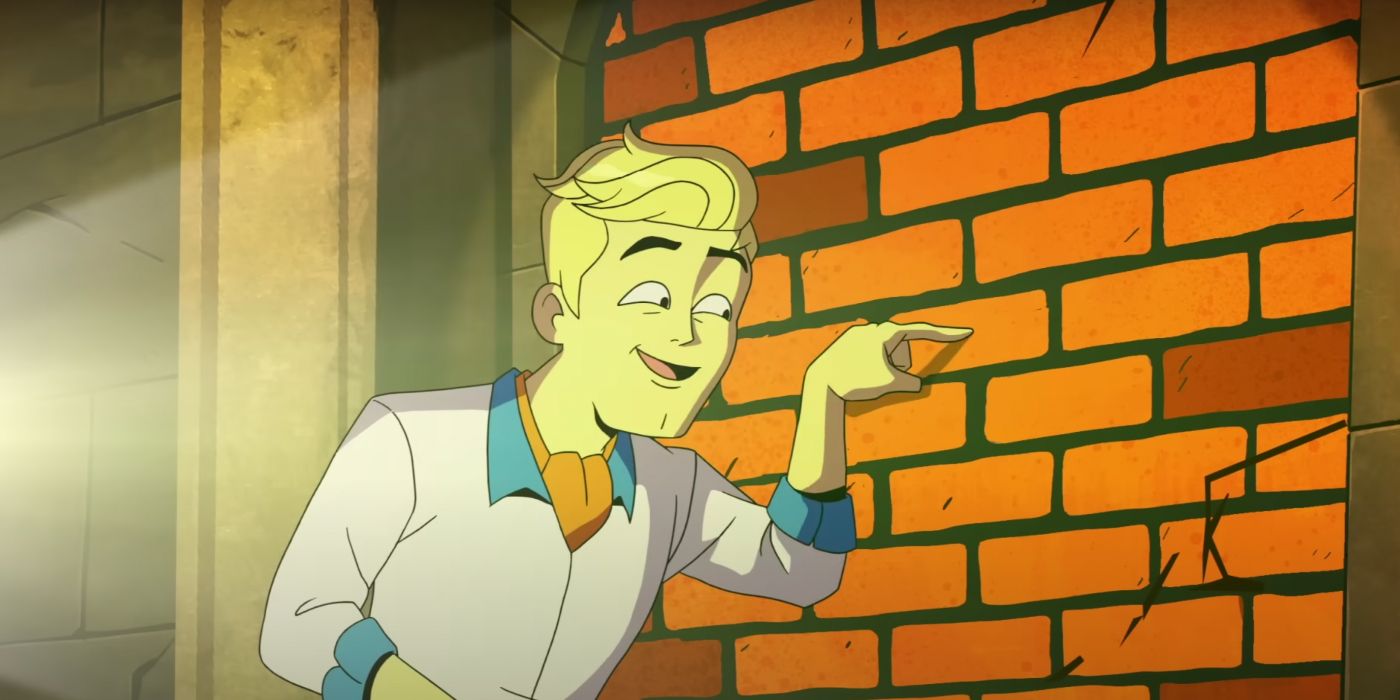 Fred poking a brick wall and smiling in Velma
