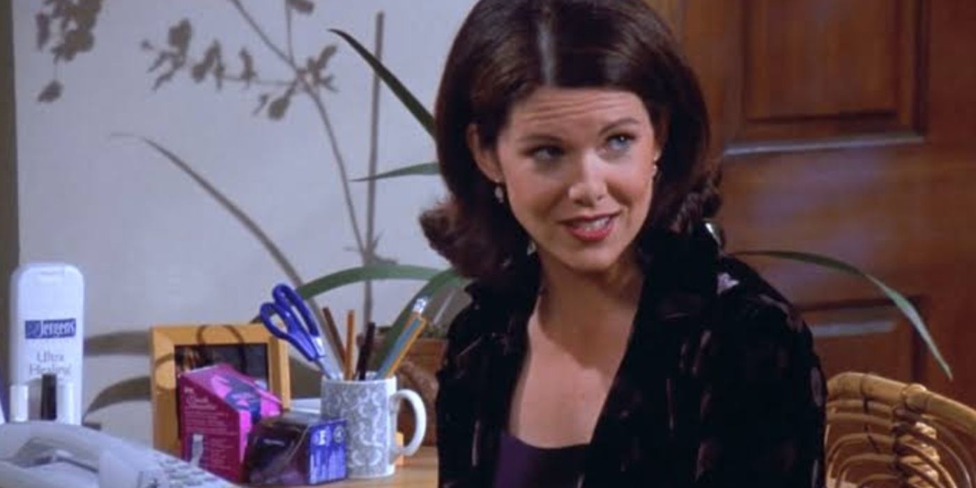 Lauren Graham as Valerie sitting at her desk on Seinfeld