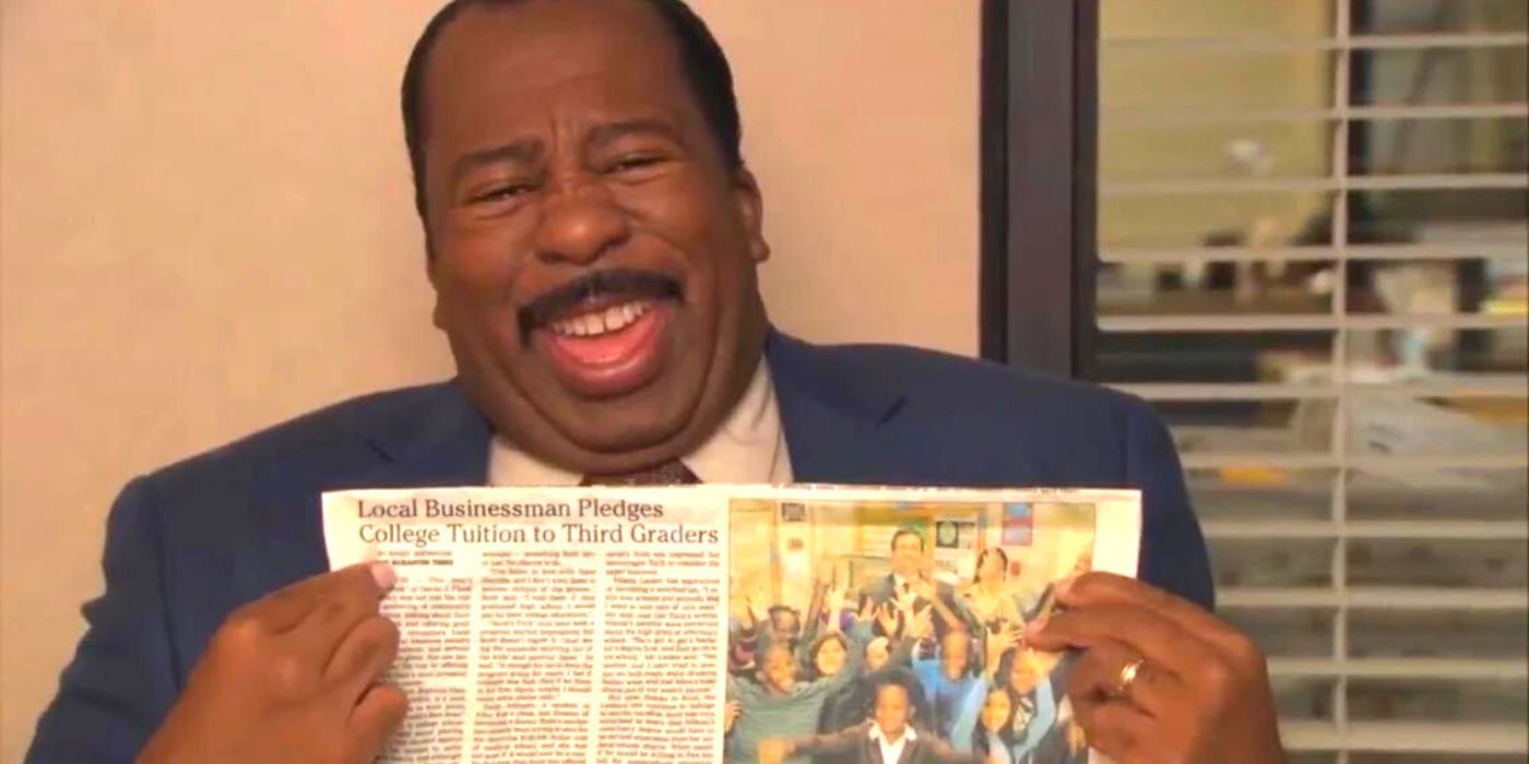 Stanley laughing while holding a newspaper showing Scott's Tots in the Office