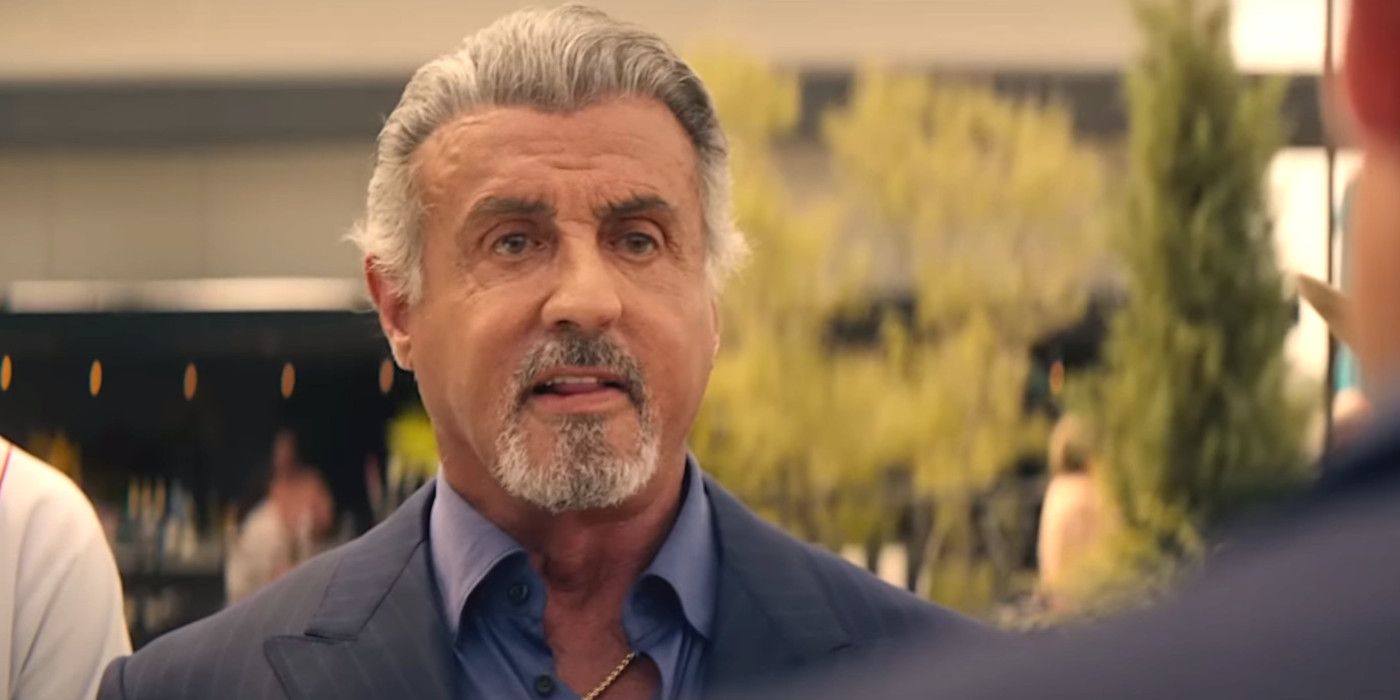 Sylvester Stallone in Tulsa King season 1 with gray hair and goatee looking confrontational in the street