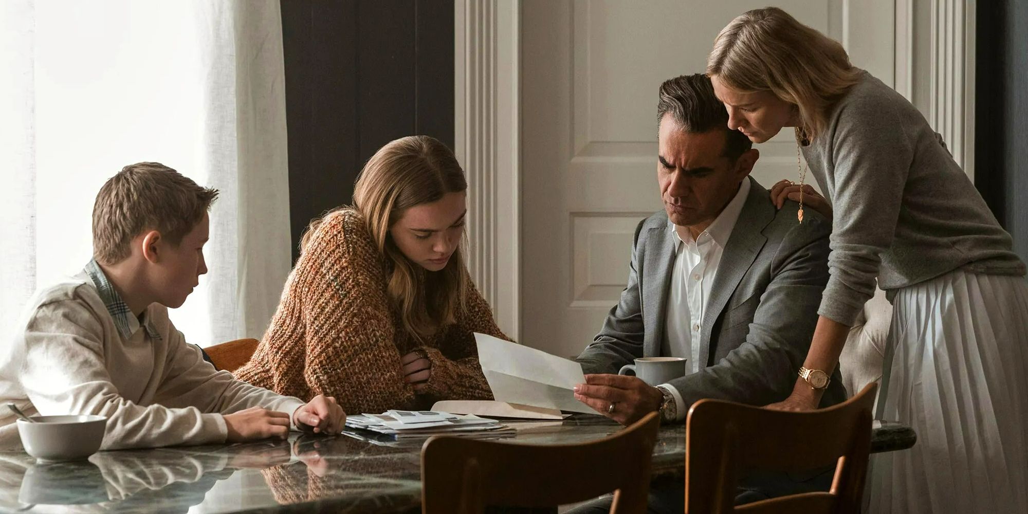 The Brannock family in The Watcher gathered at table looking at letter