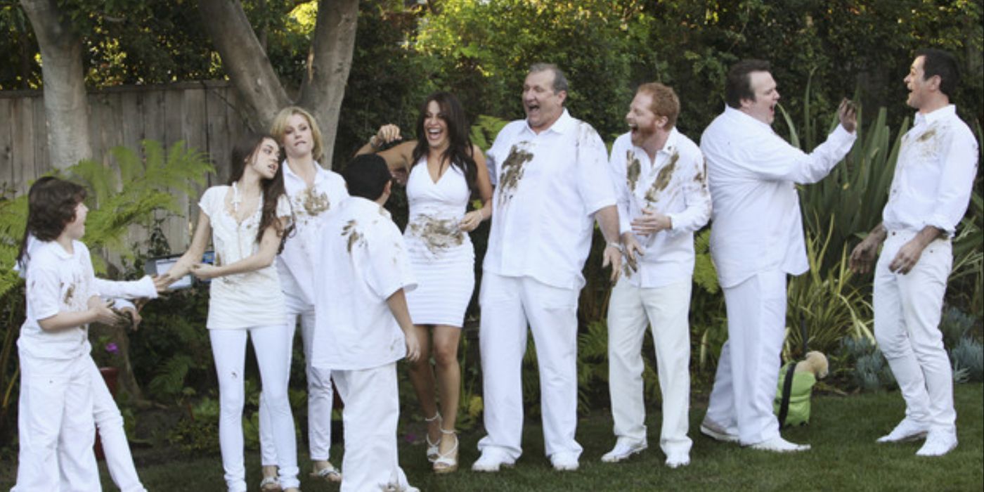 The cast of Modern Family smiling for a photo in the season 1 finale