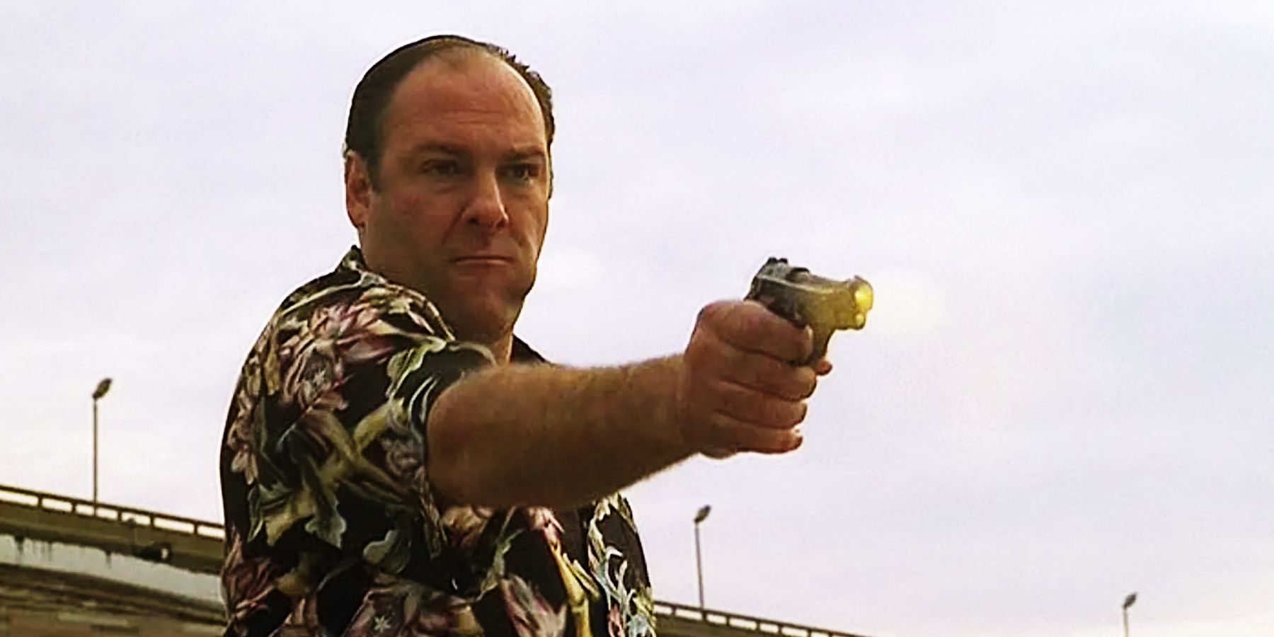 Tony Soprano em sua camisa preta floral matadora, batendo em Chucky Signore