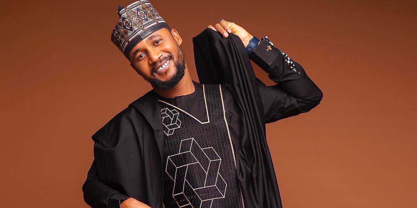 Usman Umar from 90 Day Fiance posing for the camera in traditional Nigerian clothes