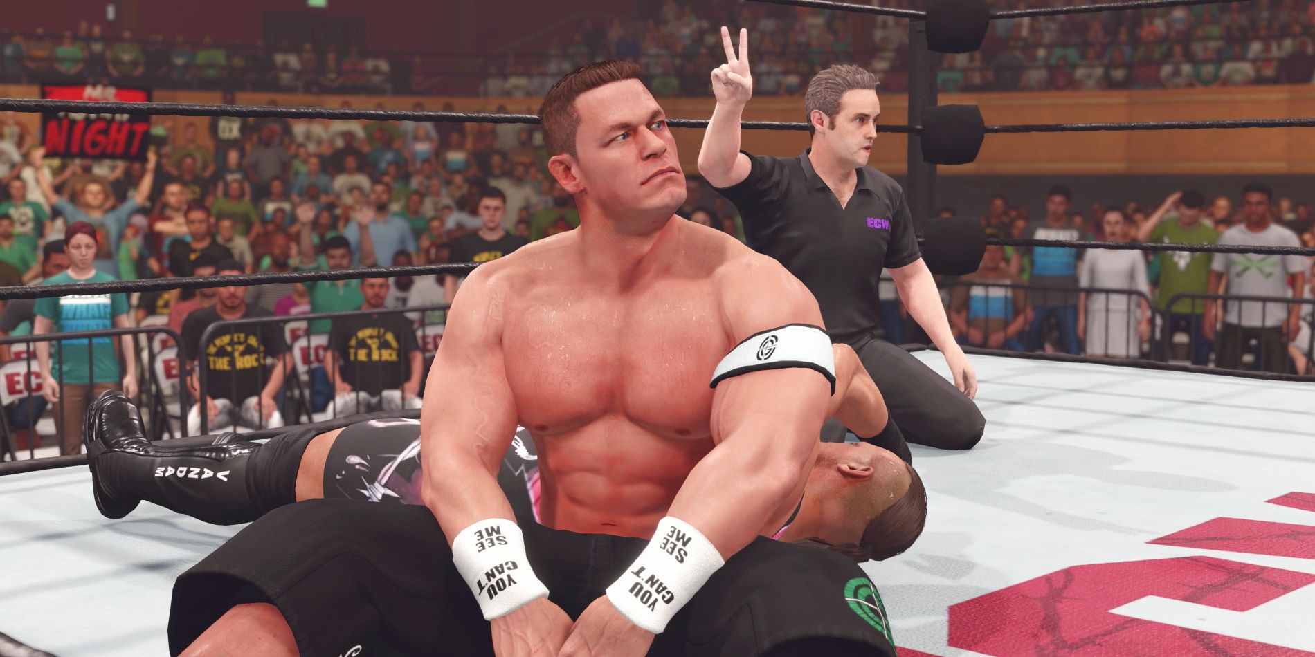 Wrestler John Cena is seen looking disappointed while in the ring with RVD after having his opponent escape a pin at the count of two. The referee is seen holding two fingers up in the background.