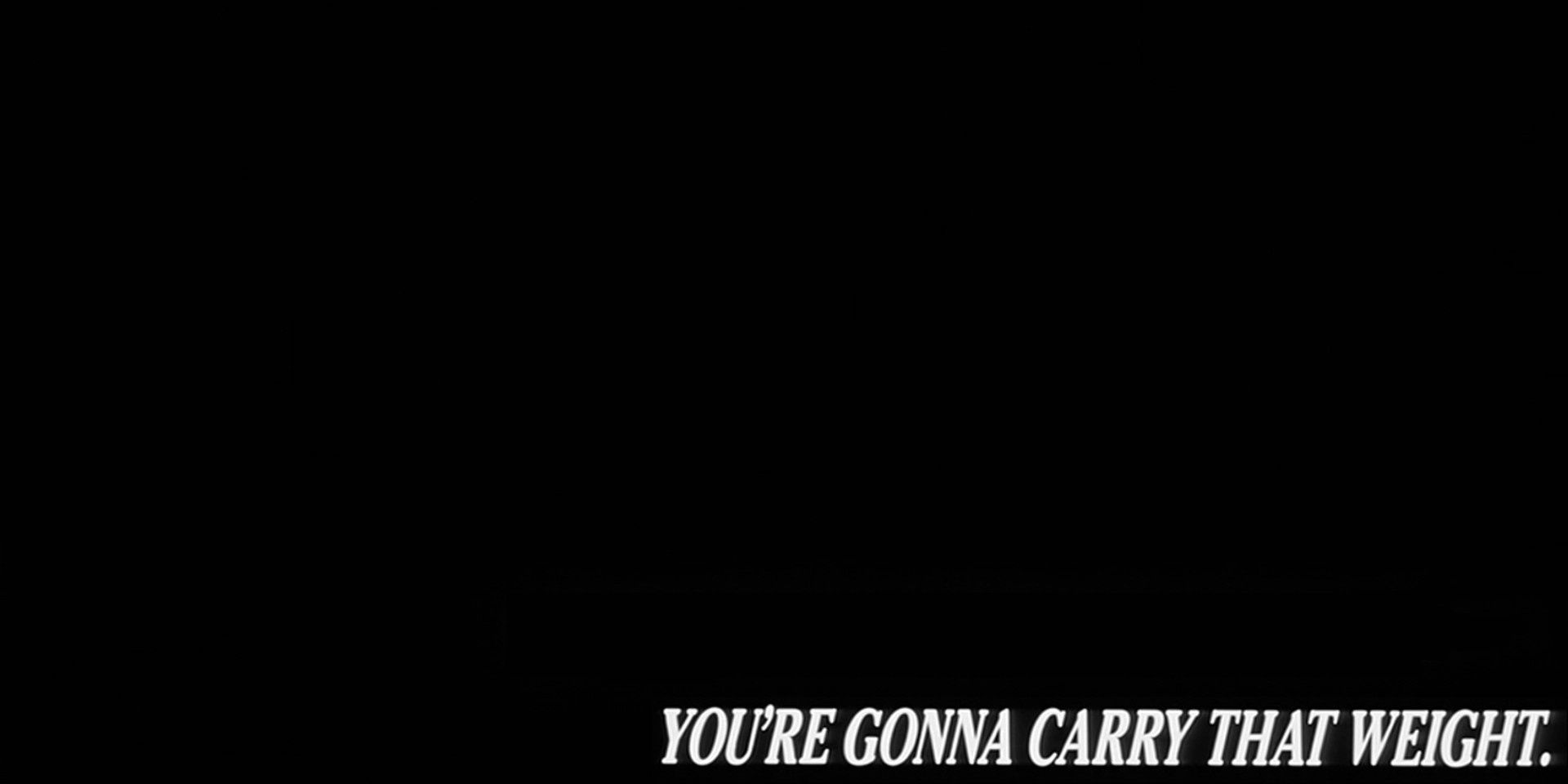 A black screen with the words, “You’re gonna carry that weight,” in all caps white font in the lower right corner.