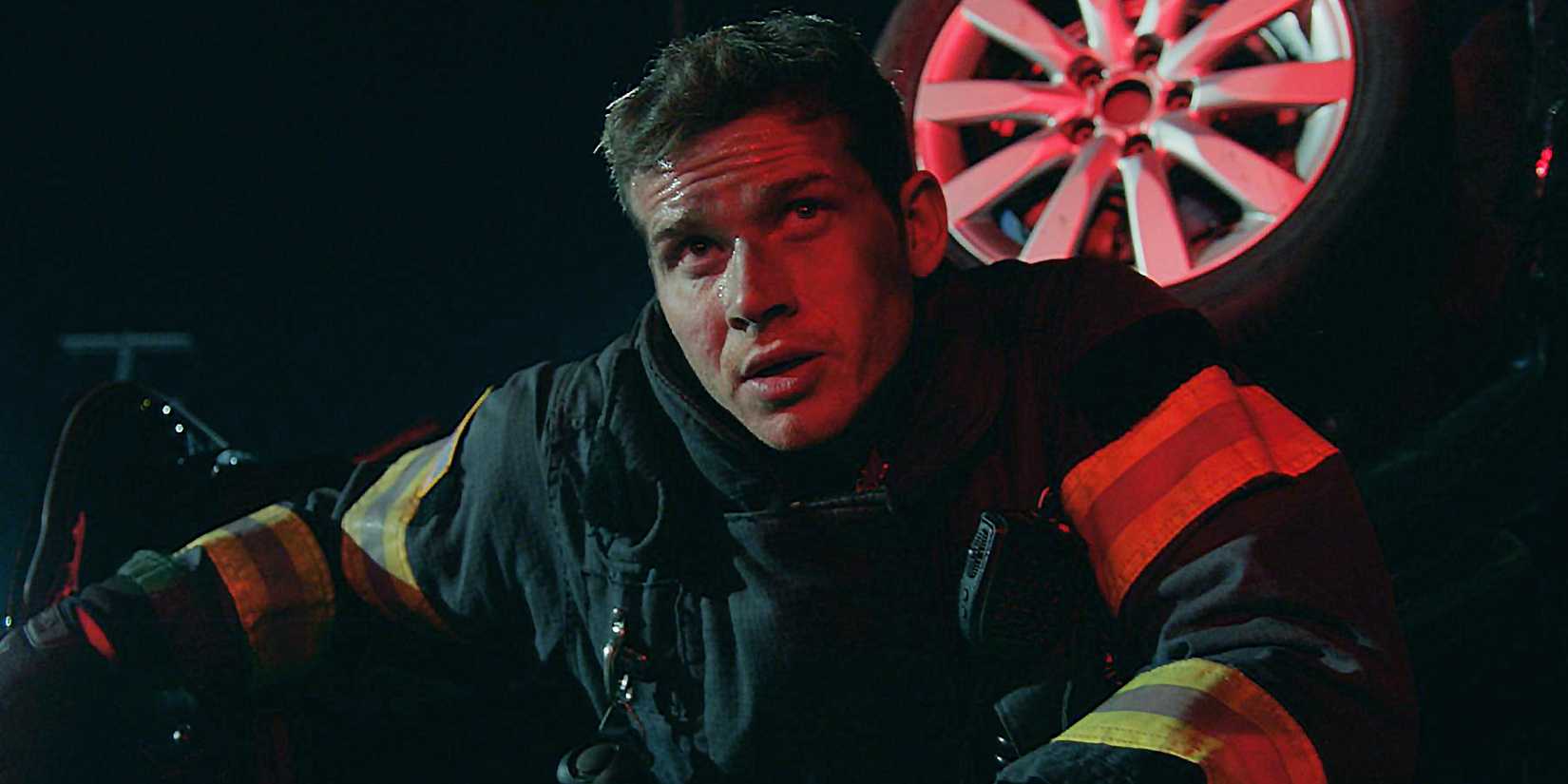 Buck looks on while covered in soot at an accident scene in 9-1-1