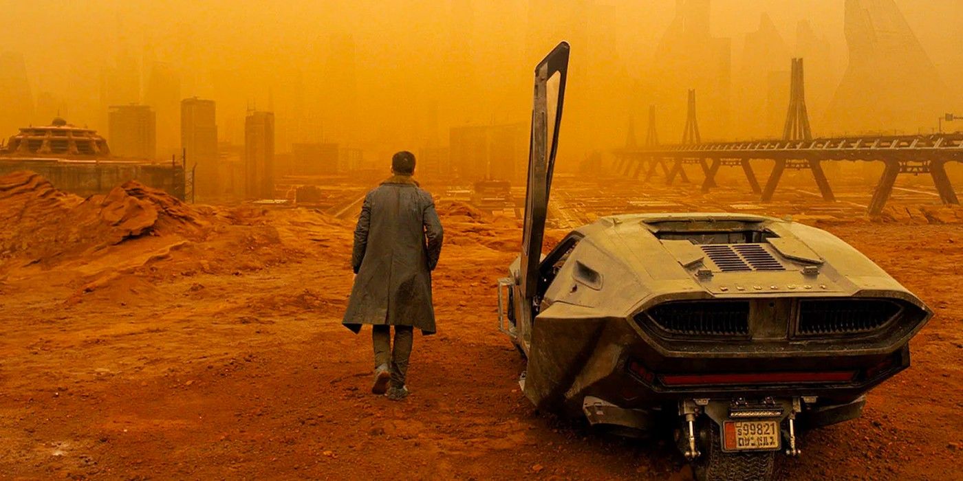 K walking away from his car towards the orange haze of the Las Vegas skyline in Blade Runner 2049