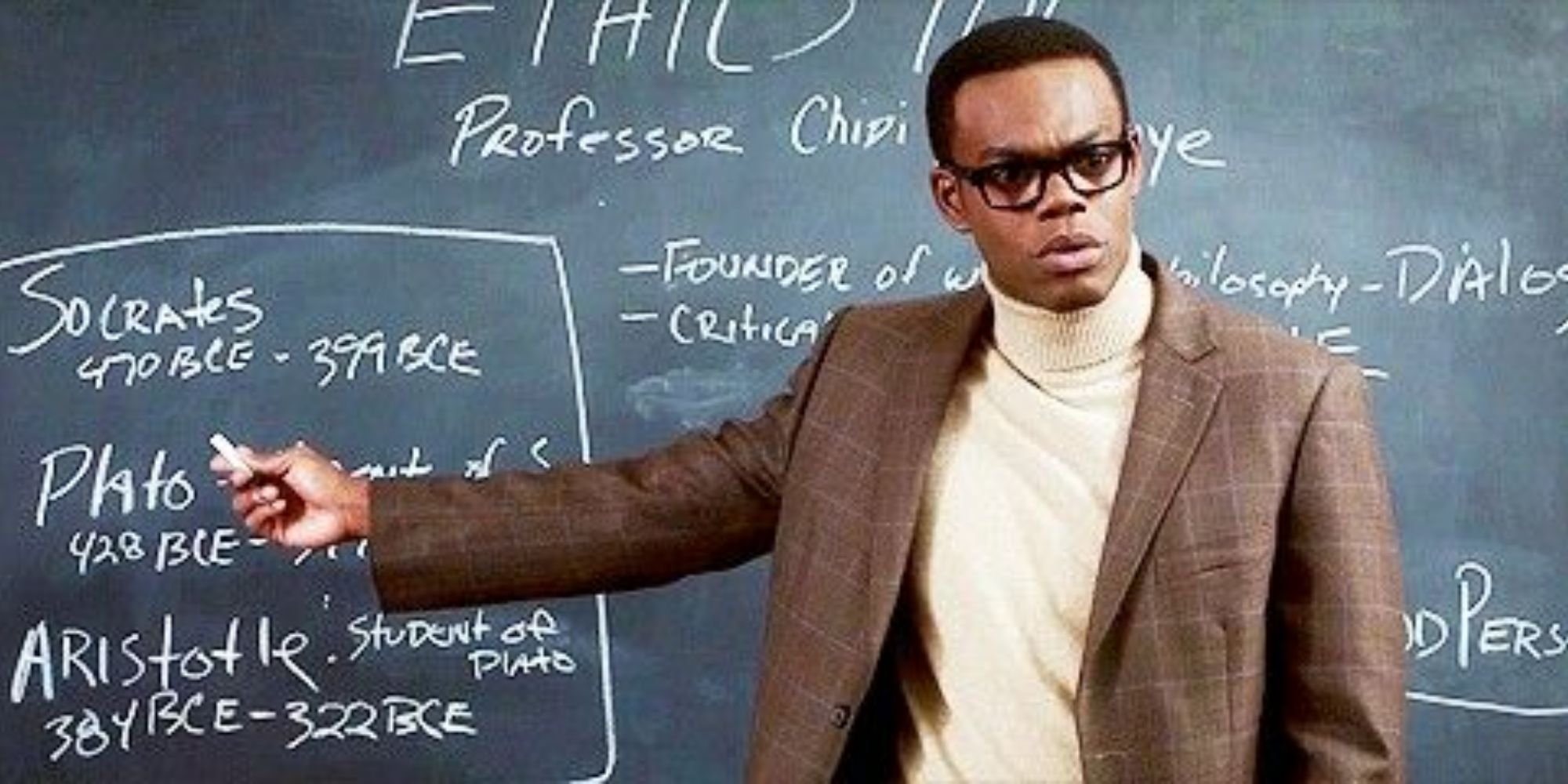 Chidi in front of a blackboard