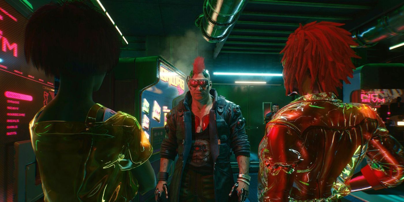 A man with a red mohawk standing in between two women with their backs faced to the camera in Cyberpunk 2077.