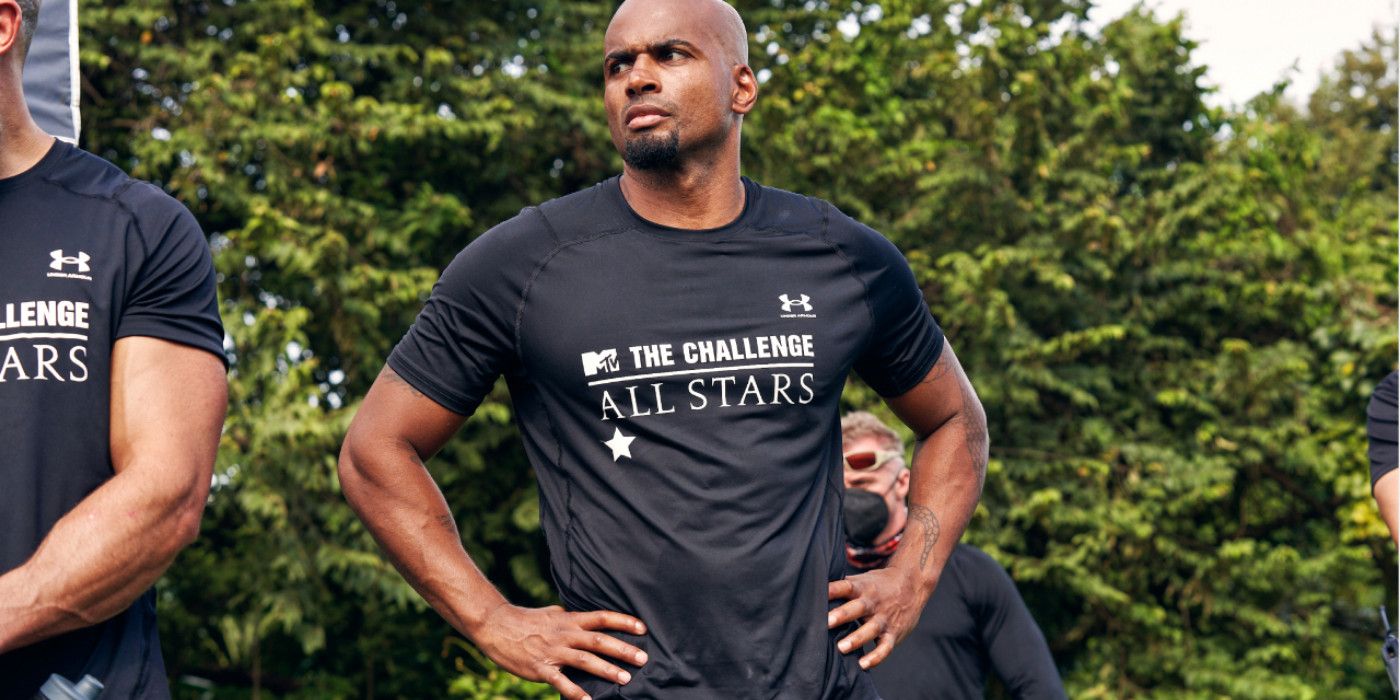 Darrell Taylor on The Challenge. He is standing with his hands on his hips with a serious expression on his face. 