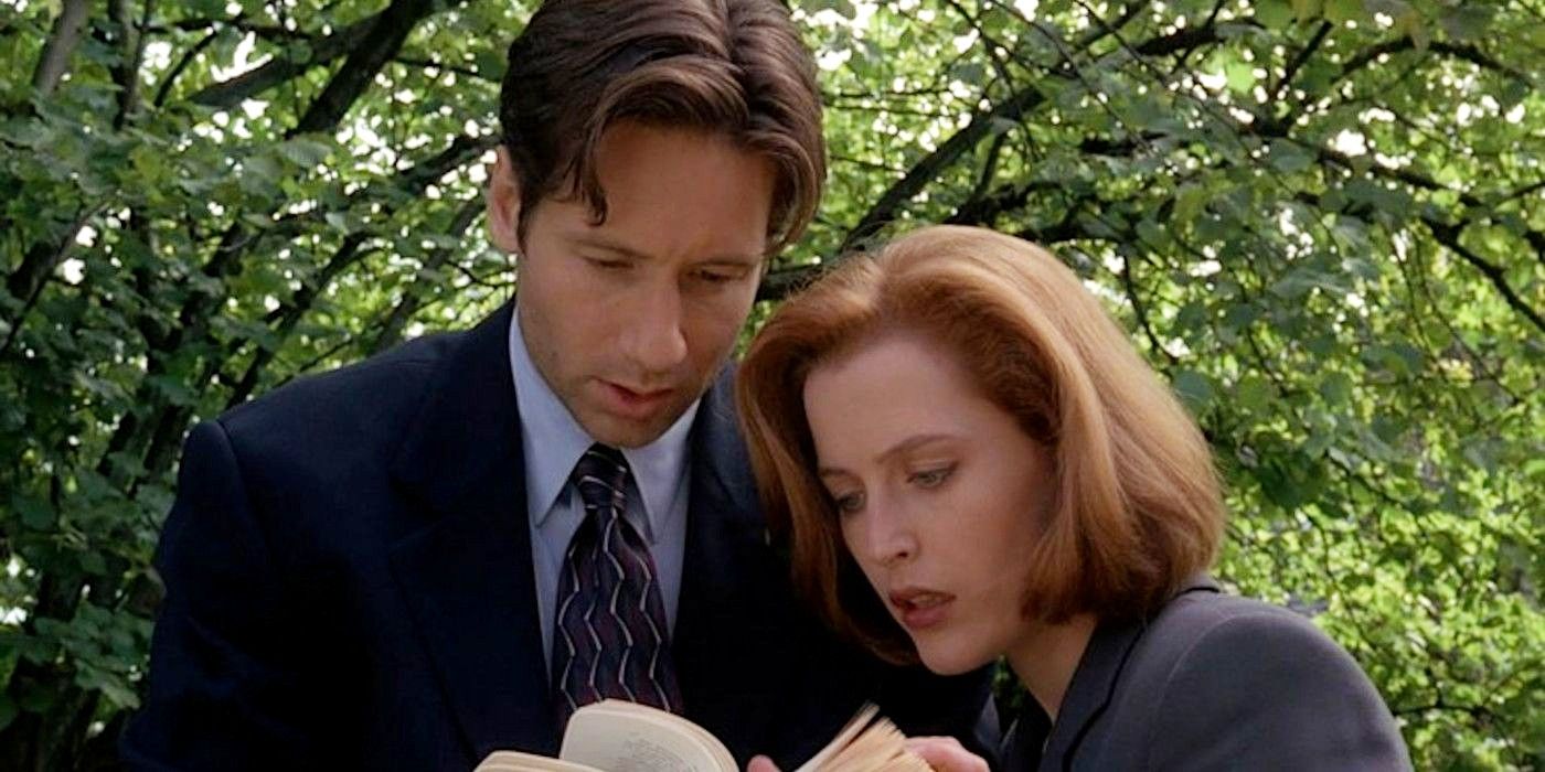 David Duchovny and Gillian Anderson on The X-Files looking at a book with intrigue